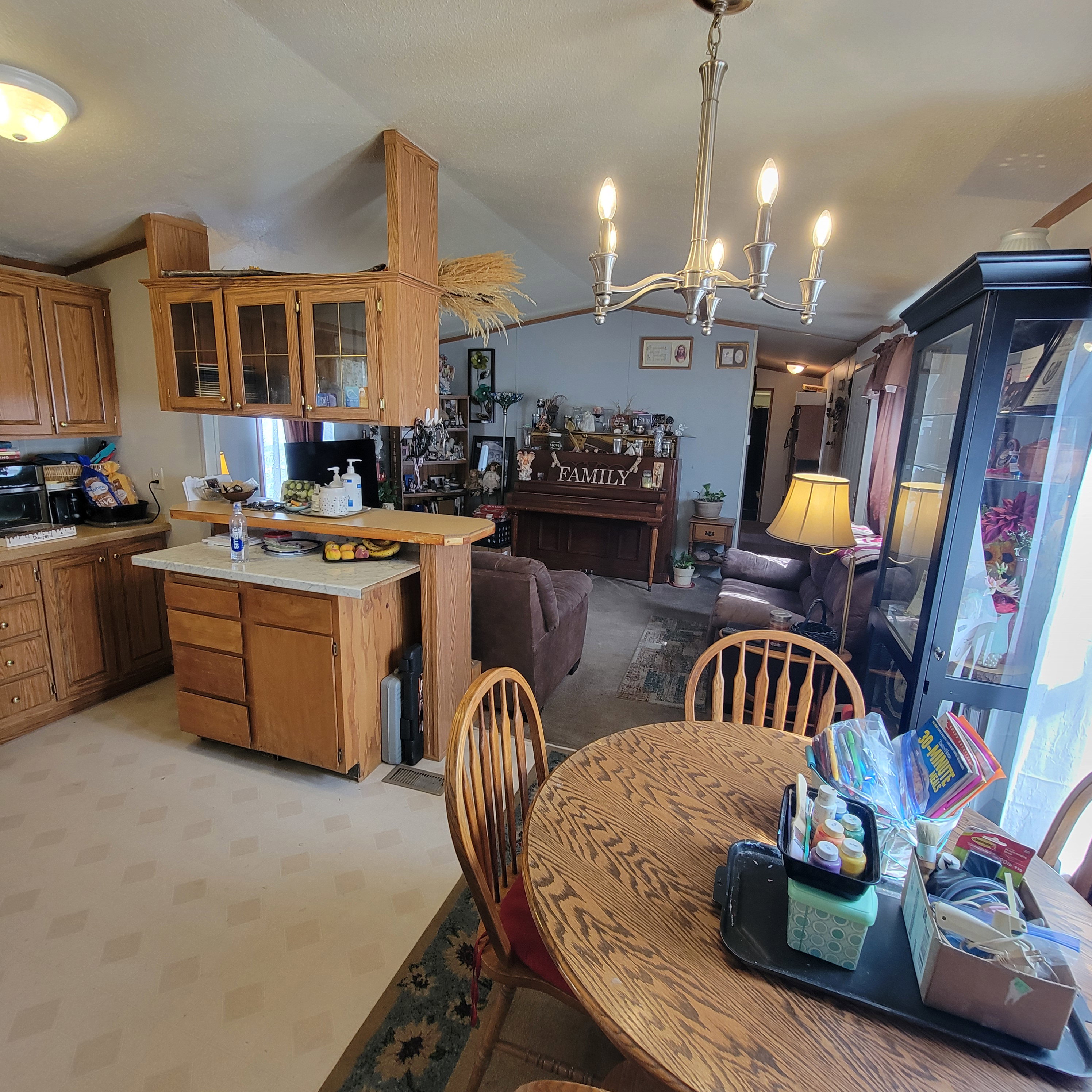 Dining room with vaulted ceiling, suspended lighting, and light colored carpet