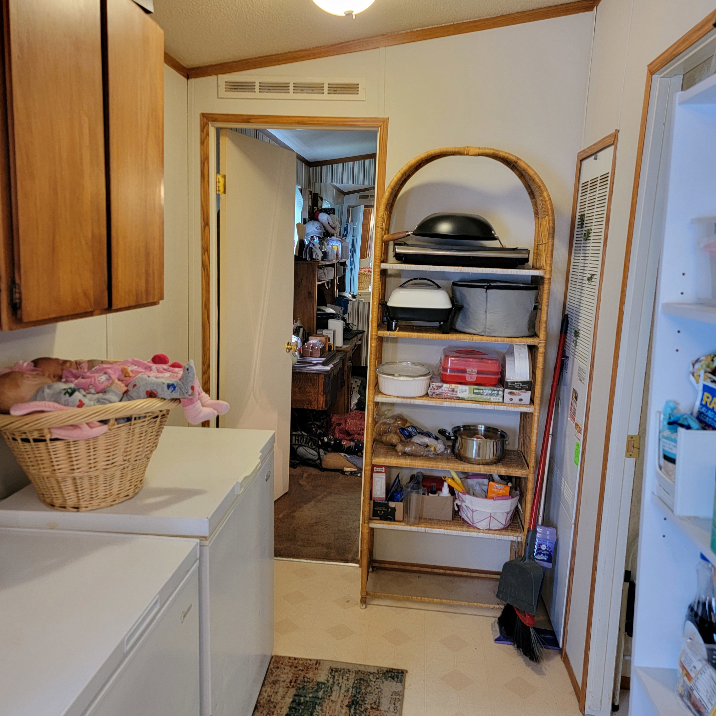 Laundry area featuring light floors, washing machine and dryer, crown molding, and cabinet space