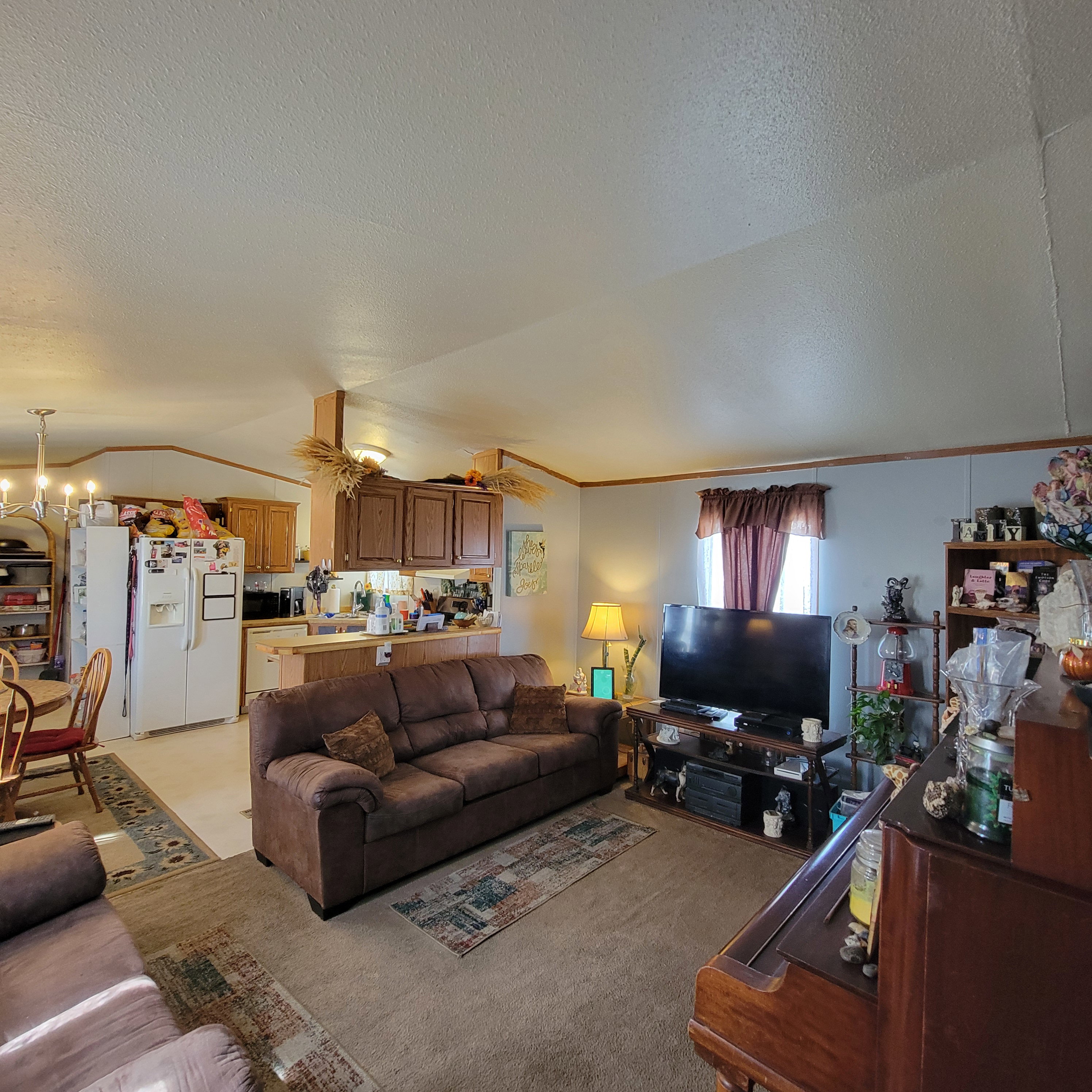 Living room featuring a chandelier, carpet flooring, and crown molding