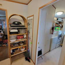 Bathroom with a closet, light flooring, crown molding, independent washer and dryer, and a heating unit