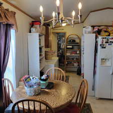 Dining room featuring light floors, suspended lighting, and ornamental molding