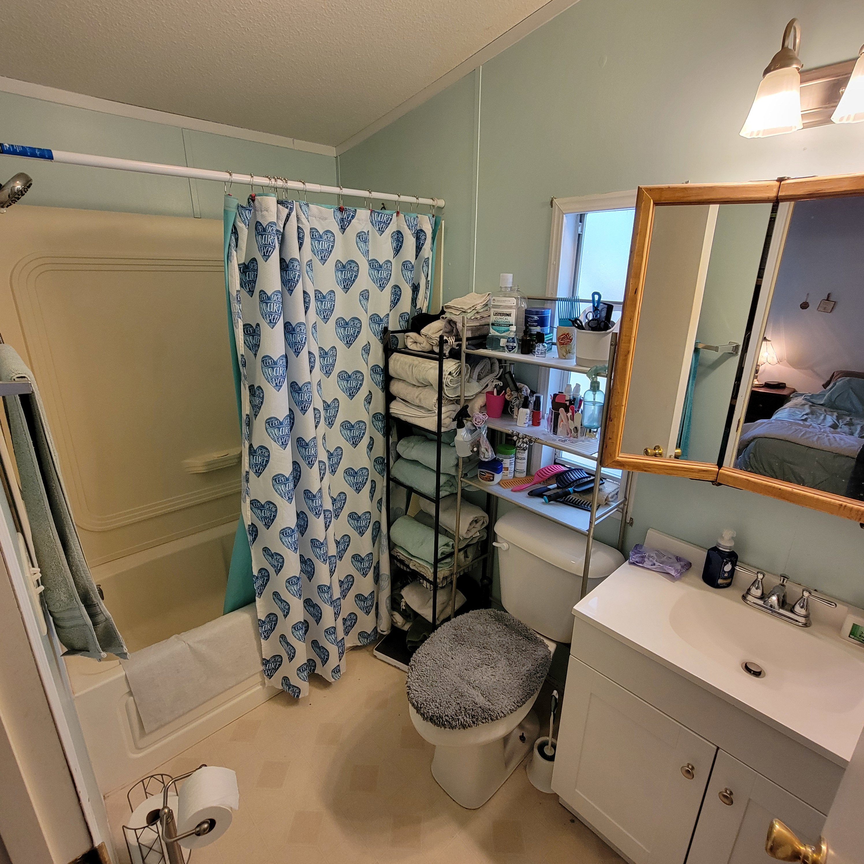 Ensuite bathroom featuring shower / tub combo, vanity, and a textured ceiling