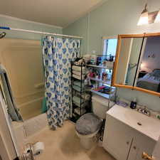 Ensuite bathroom featuring shower / tub combo, vanity, and a textured ceiling
