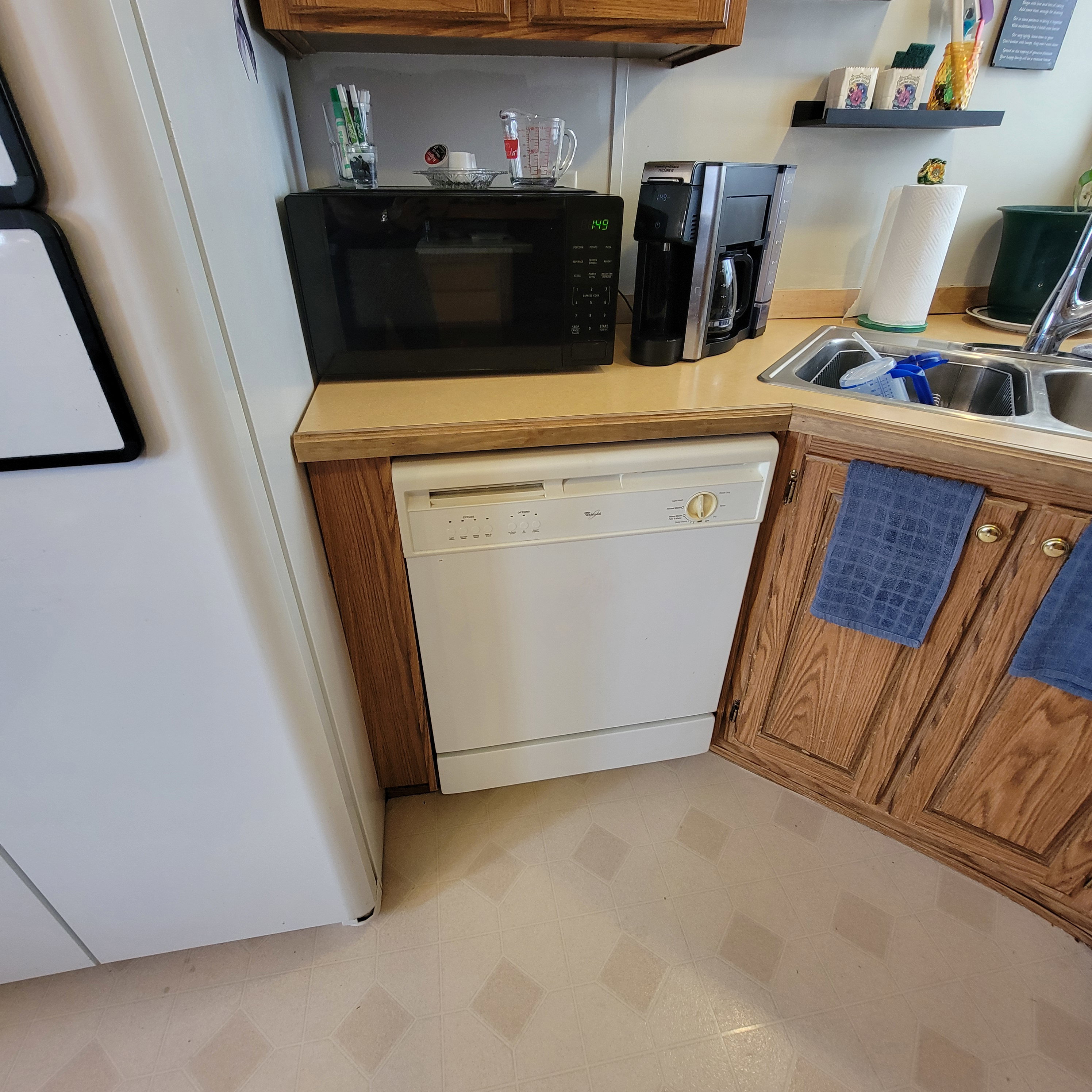 Kitchen featuring white appliances, light countertops, wood finish cabinets, open shelves, and light floors