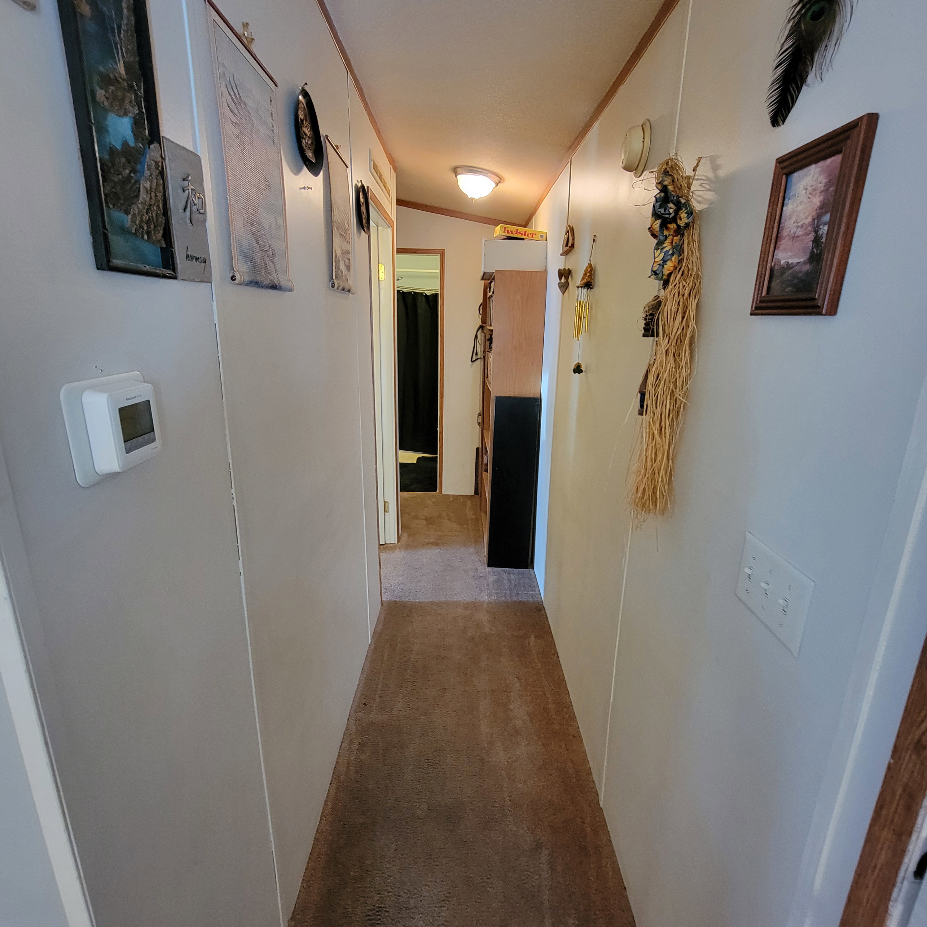 Hallway with light colored carpet and crown molding