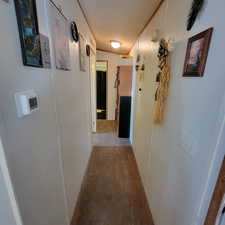 Hallway with light colored carpet and crown molding