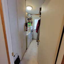 Laundry room featuring washer and clothes dryer, a textured ceiling, and light floors
