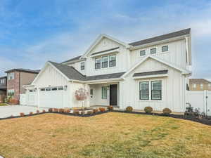 Modern farmhouse with board and batten siding, an attached garage, roof with shingles, concrete driveway, and covered porch