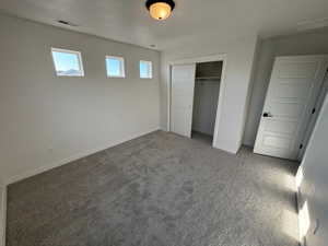 Unfurnished bedroom featuring carpet flooring and a closet