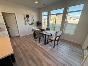 Dining space with light wood-style floors and recessed lighting