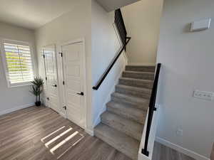 Staircase featuring baseboards and wood finished floors
