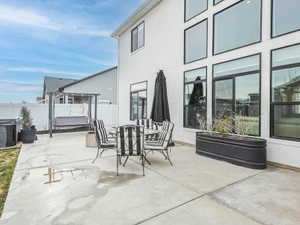 Fenced backyard featuring outdoor dining space, a patio area, and a hot tub