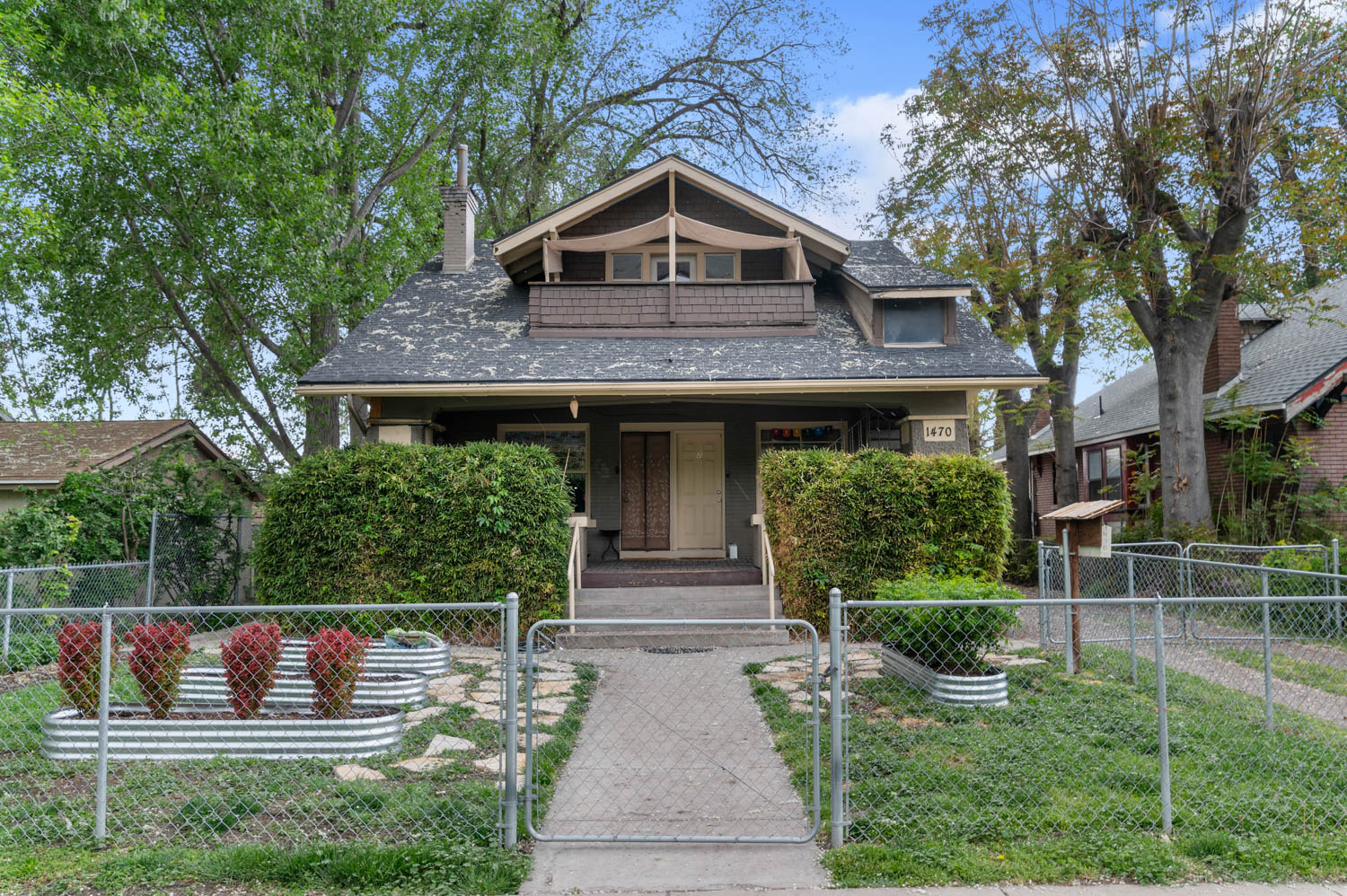 Craftsman-style residence featuring a prominent gabled dormer and an upper-level balcony