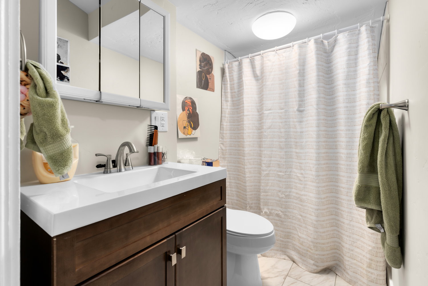 Full bathroom featuring curtained shower and vanity