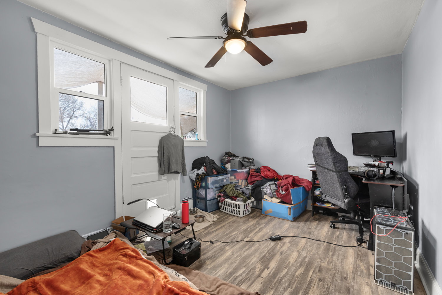 Bedroom with a desk, wood finished floors, and a ceiling fan