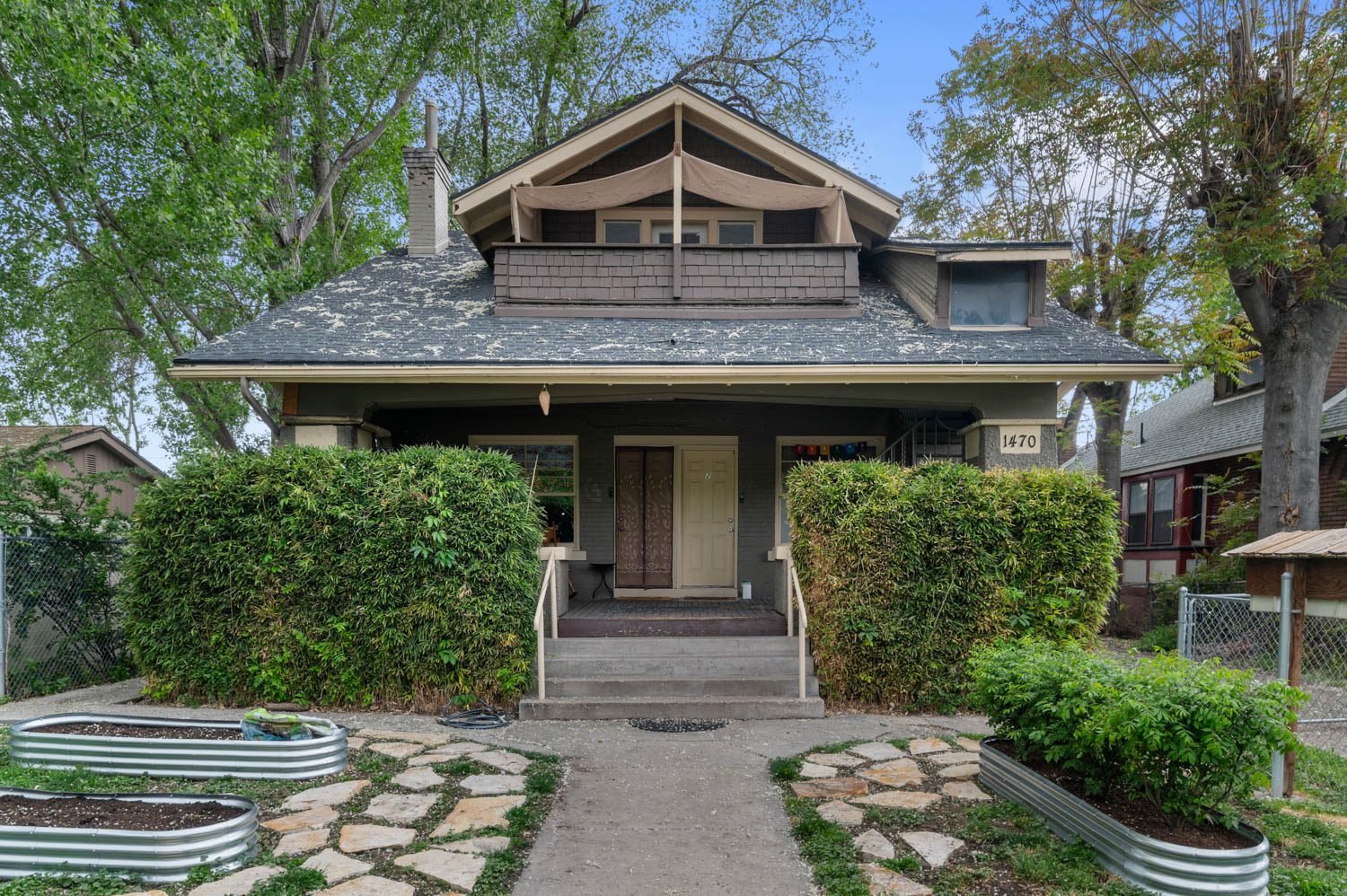 Craftsman-style residence featuring a prominent front porch, dormer window, and shingle siding accents
