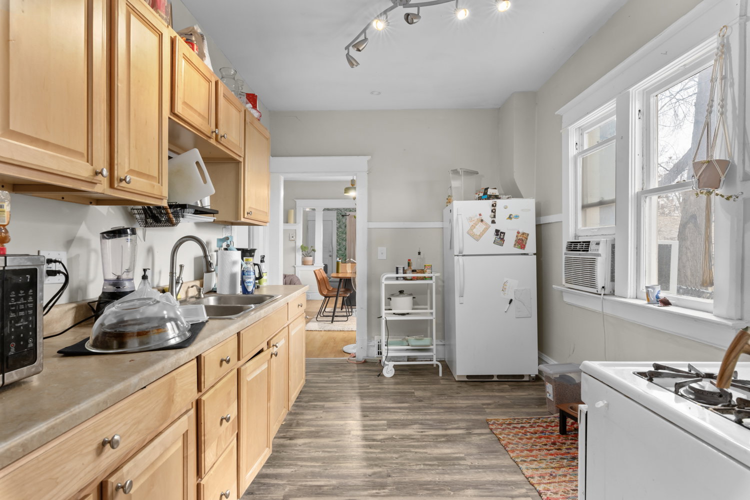 Kitchen with white appliances, light countertops, dark wood finished floors, light wood finish cabinets, and cooling unit