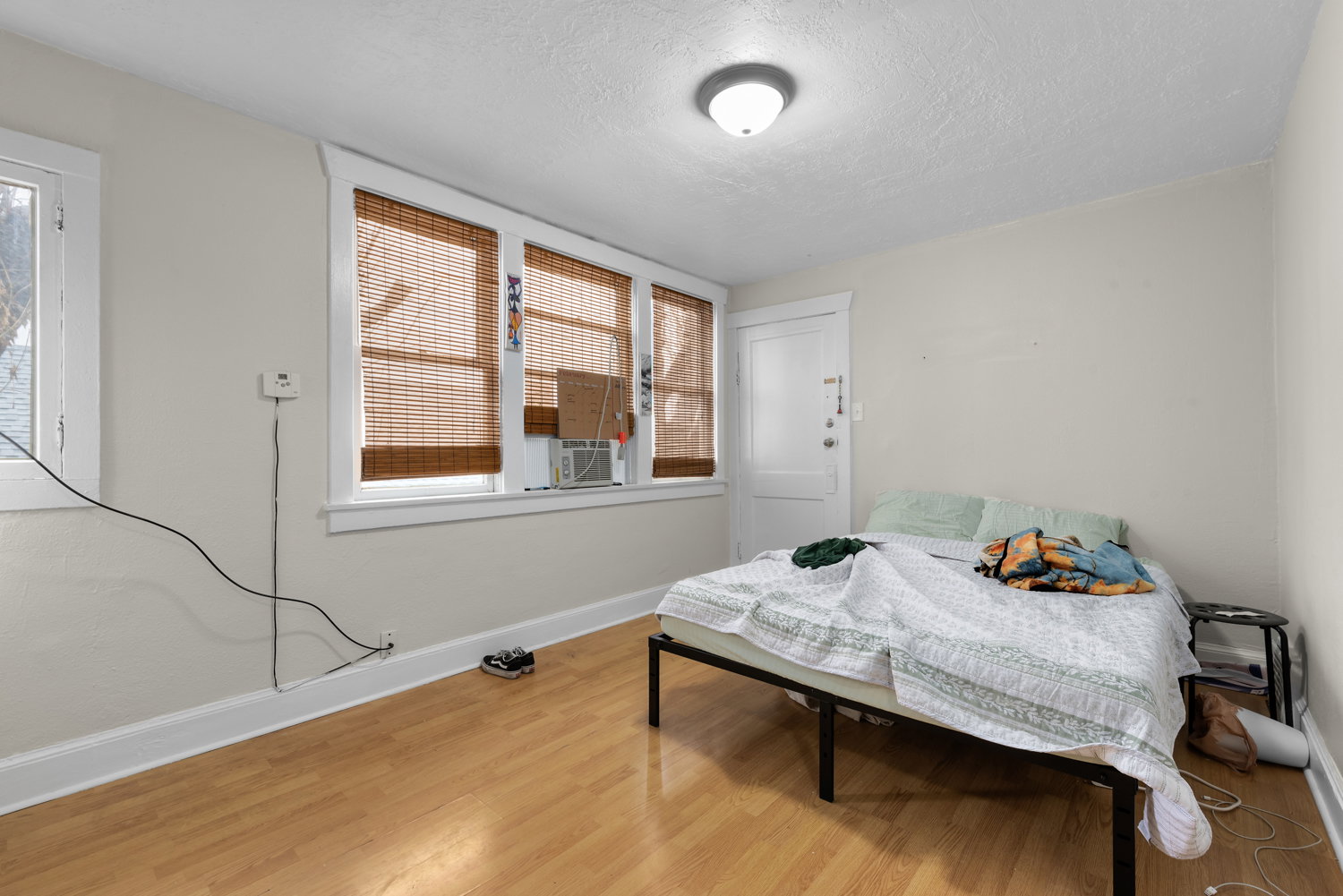 Bedroom with light wood-style floors and a textured ceiling