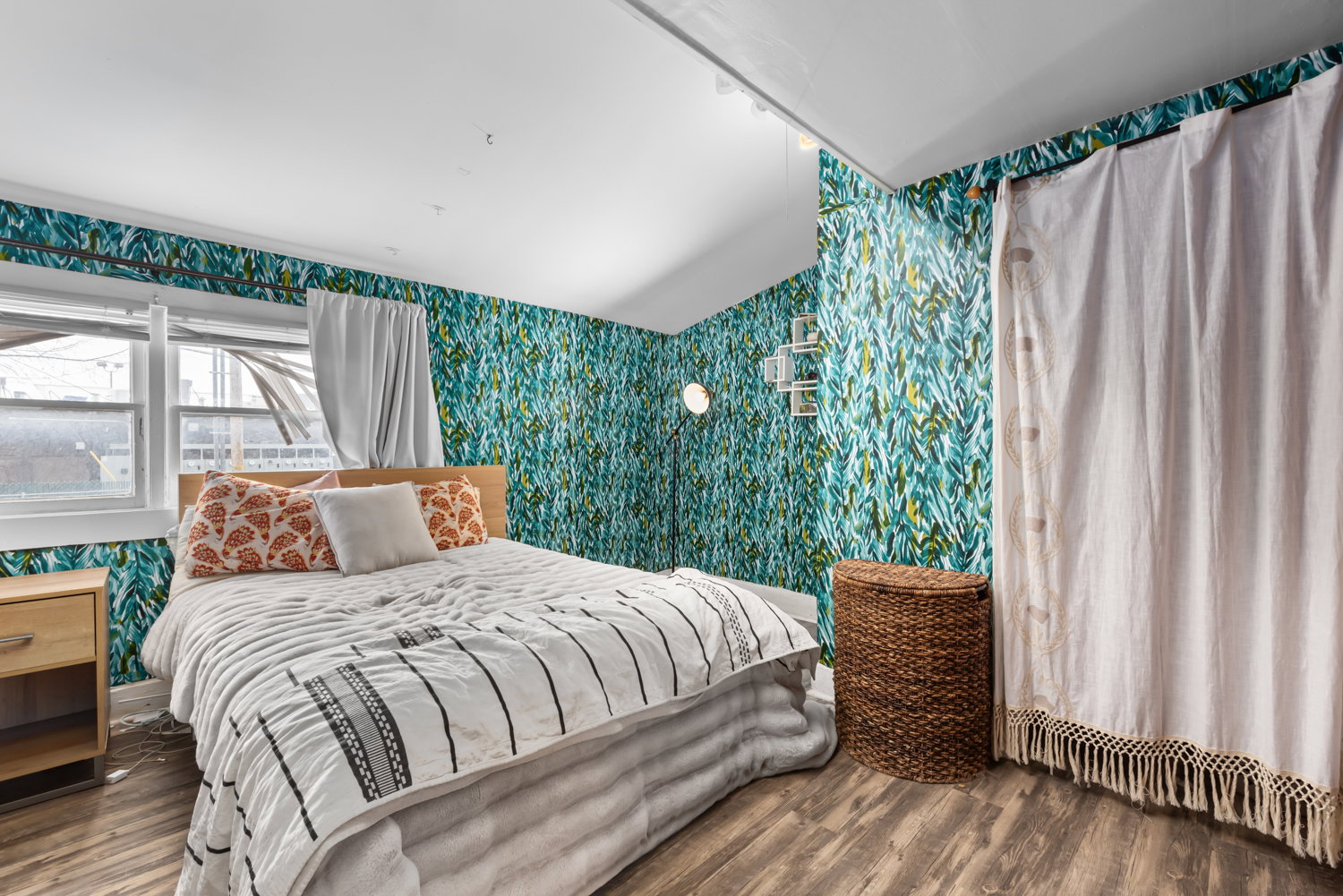 Bedroom with wallpapered walls, wood finished floors, and track lighting