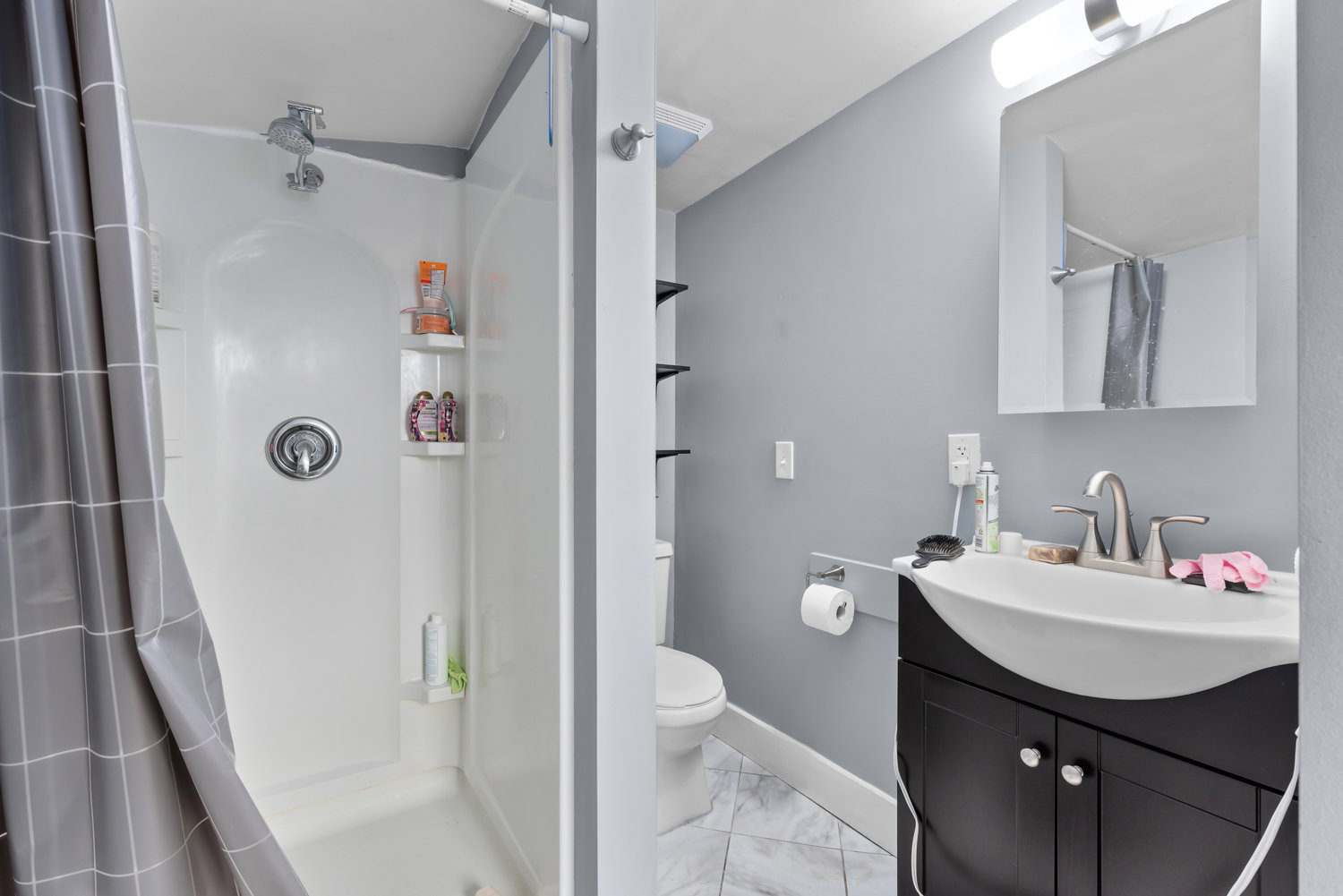 Full bathroom with a shower stall, vanity, and light marble finish floors