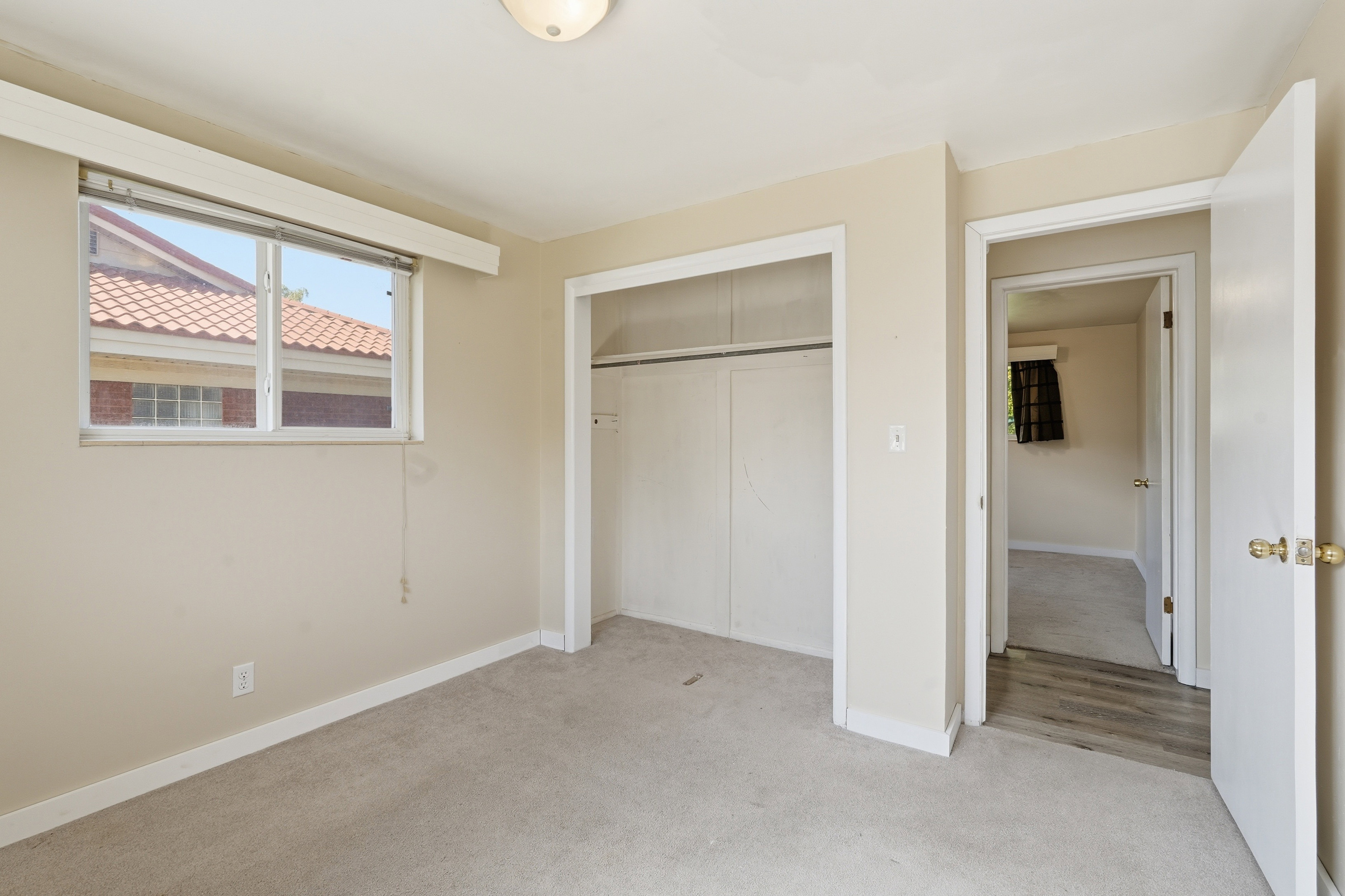 Unfurnished bedroom featuring light carpet and a closet
