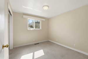 Unfurnished bedroom with light carpet and a closet