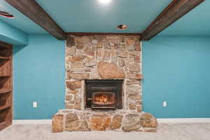 Detailed view of beam ceiling, carpet, and a fireplace