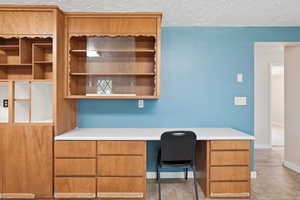 Unfurnished office featuring built in desk and baseboards