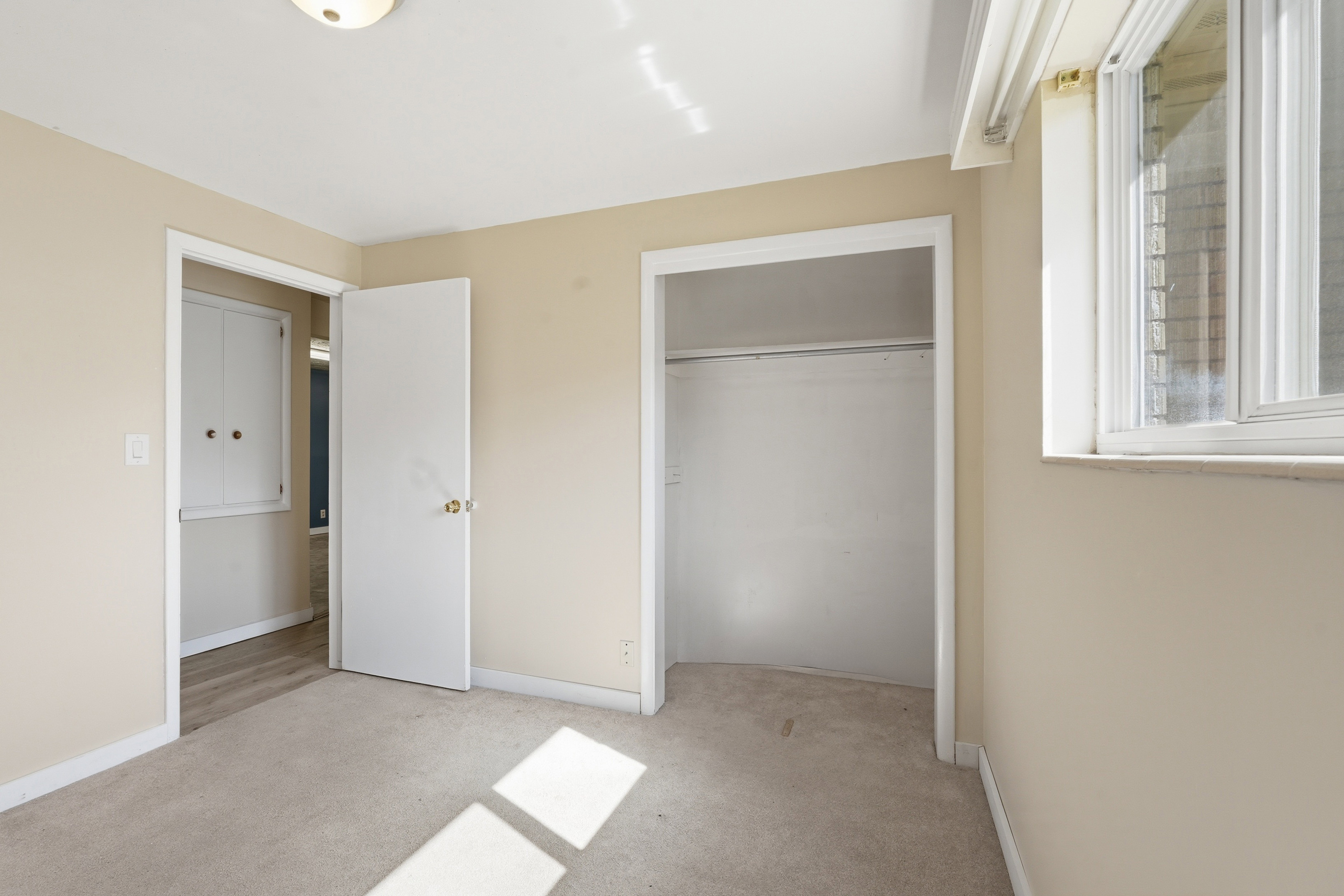 Unfurnished bedroom with light colored carpet and a closet