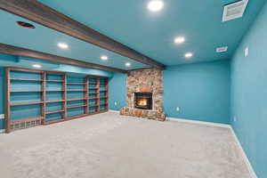 Unfurnished living room with beamed ceiling, carpet, a fireplace, and recessed lighting