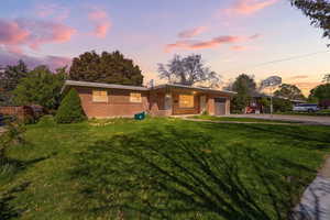Ranch-style house with an attached garage, brick siding, a front yard, and concrete driveway