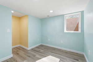 Spare room featuring light wood finished floors and recessed lighting