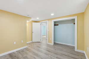 Unfurnished bedroom with light wood-style floors, recessed lighting, and a closet
