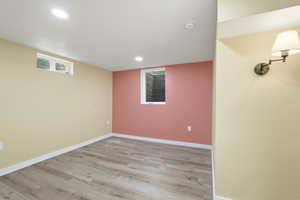 Empty room with light wood-style flooring and recessed lighting