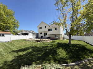 Back of house with a patio, a fenced backyard, and a storage unit