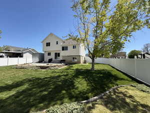 Rear view of property featuring a fenced backyard and a patio