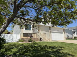 Single story home featuring concrete driveway and an attached garage
