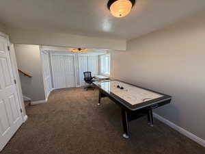 Rec room featuring a textured ceiling and carpet