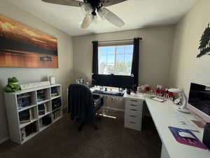 Office with ceiling fan, dark colored carpet, and a textured ceiling