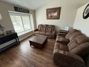 Living area featuring lofted ceiling and wood finished floors