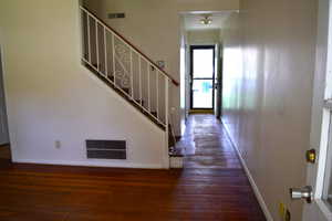 Entrance foyer featuring dark wood-style flooring and baseboards