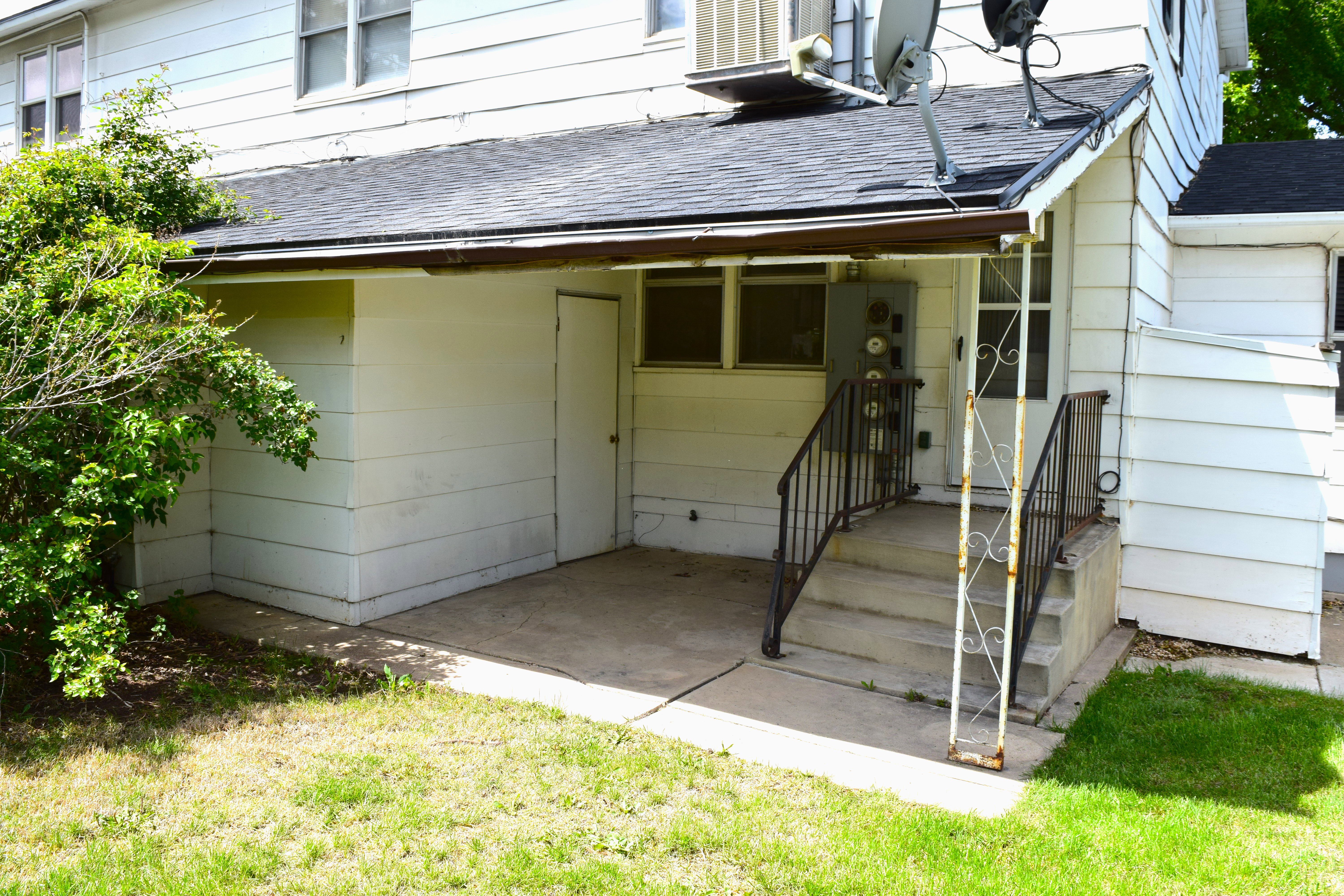 Doorway to property featuring a shingled roof