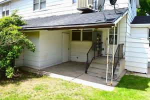 Doorway to property featuring a shingled roof