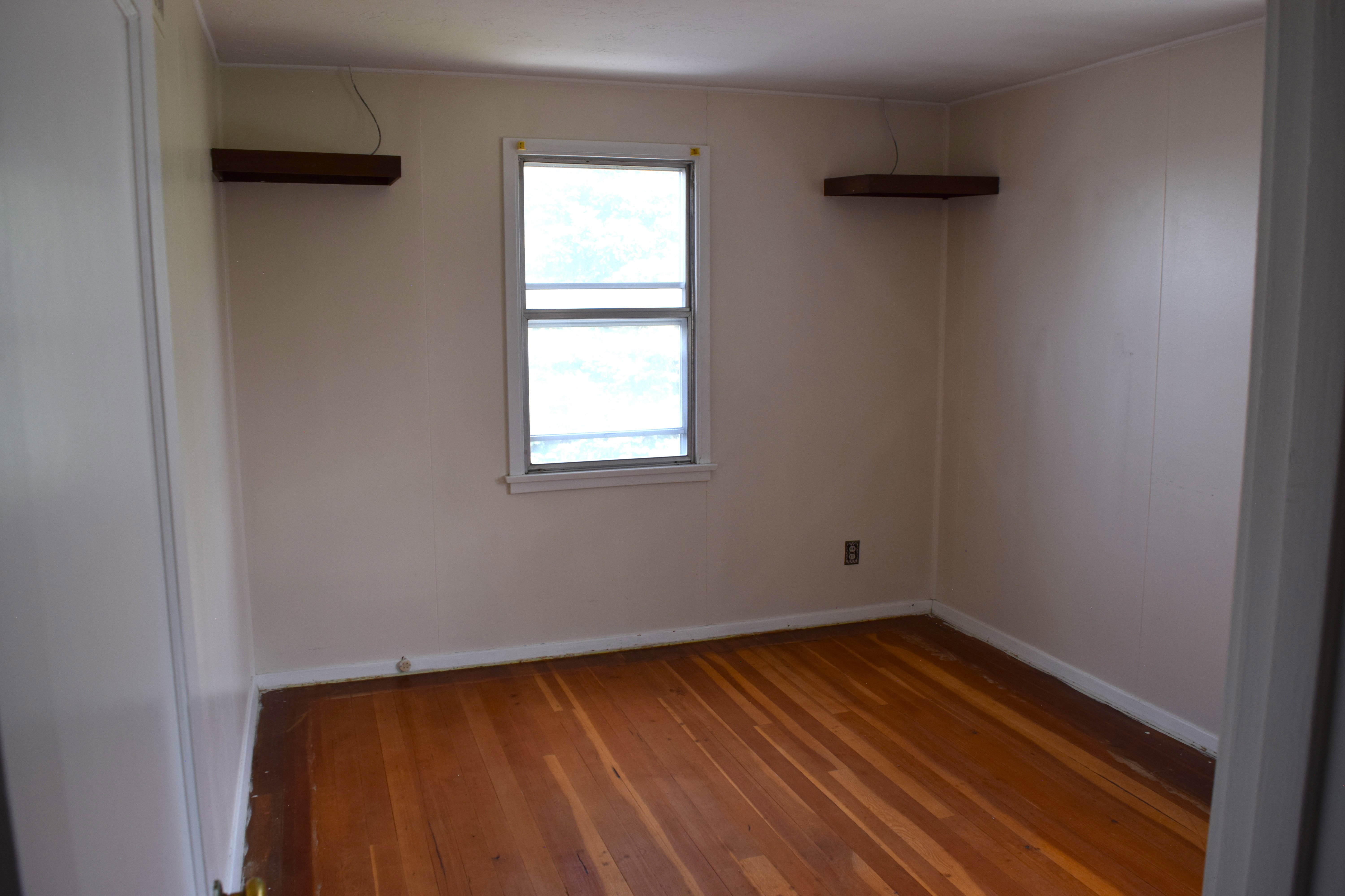 Empty room with wood-type flooring and baseboards