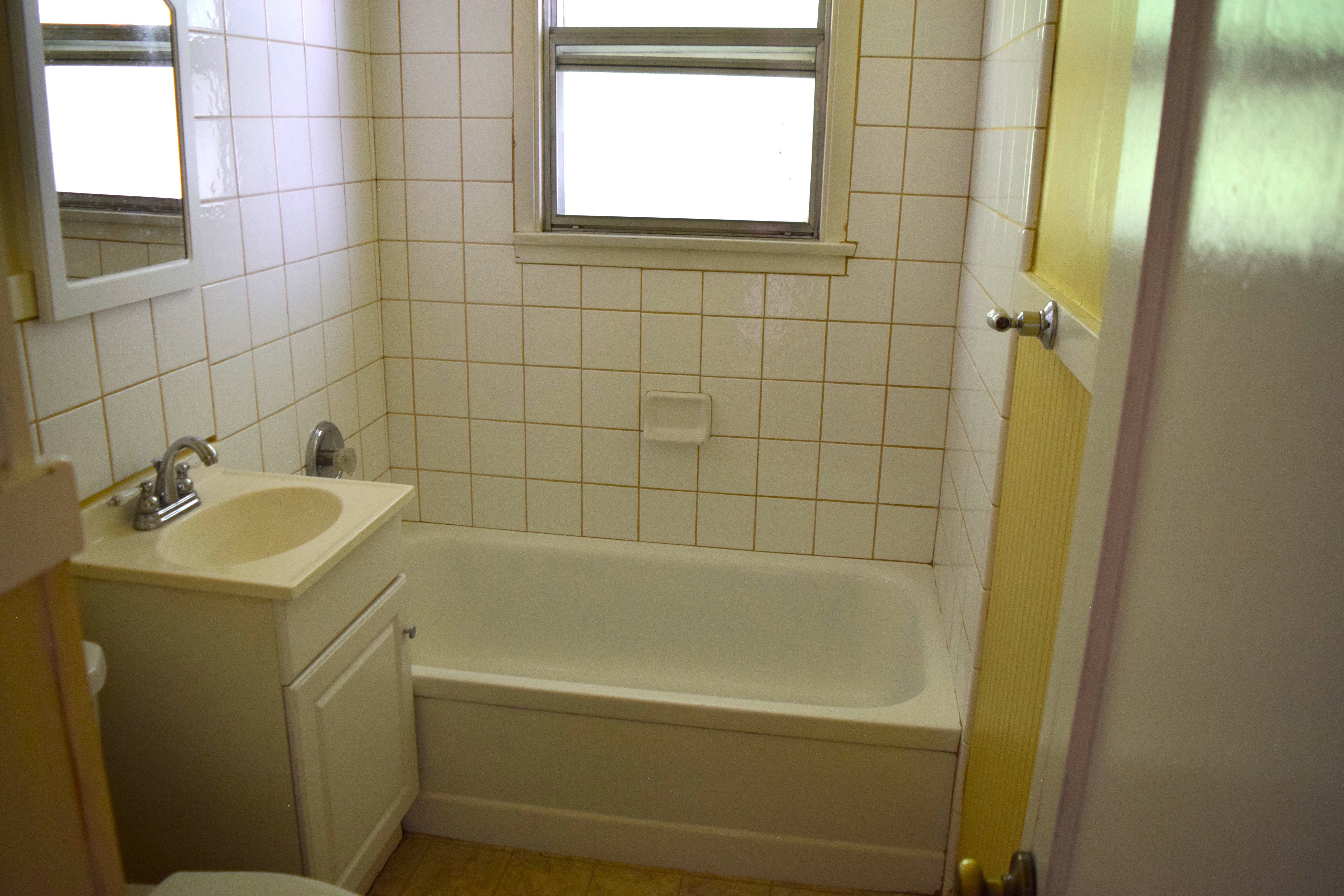 Bathroom featuring vanity, shower / tub combination, and plenty of natural light