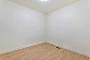Empty room with baseboards and light wood finished floors