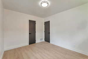 Spare room with light wood-style flooring and a textured ceiling