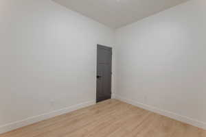 Unfurnished room featuring light wood finished floors and baseboards