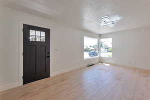 Entryway featuring light wood-style floors and a textured ceiling