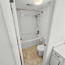 Bathroom with vanity, bathing tub / shower combination, and light tile patterned floors